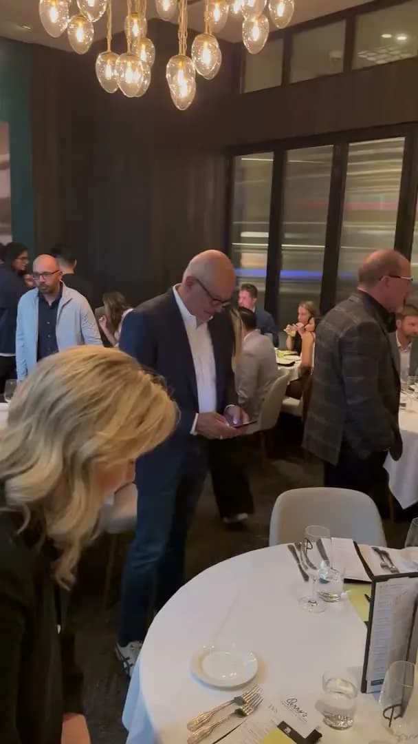 Guests arriving and finding their tables in the private dining room before the evening begins