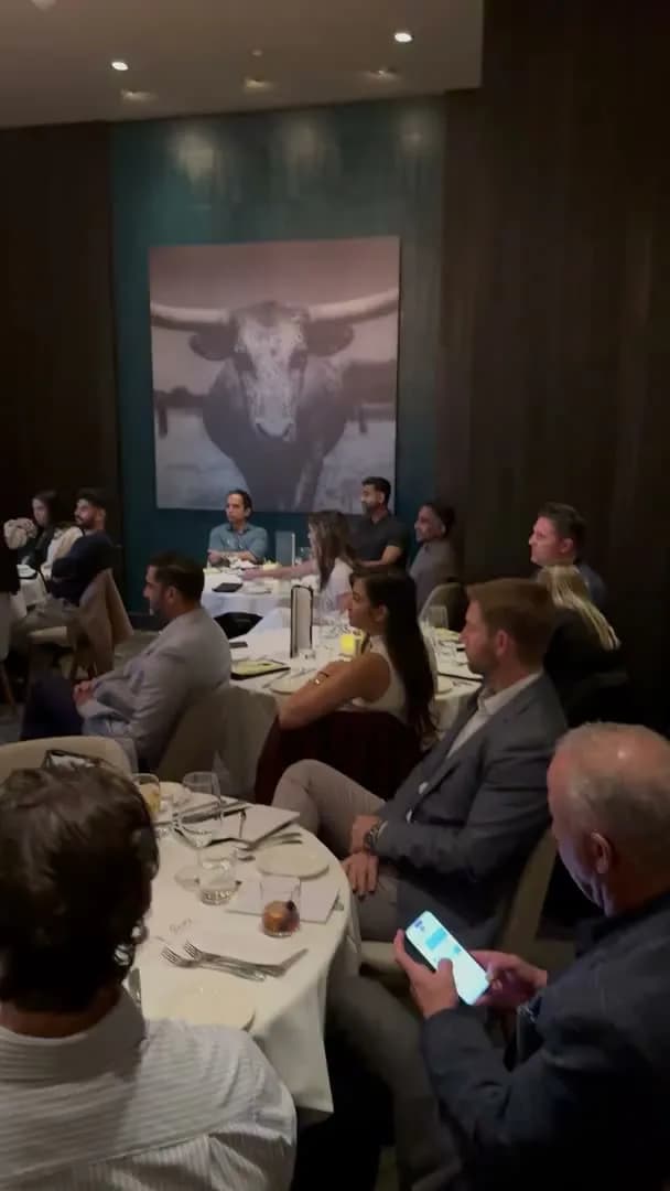 Guests watching from their tables, the longhorn photograph behind them