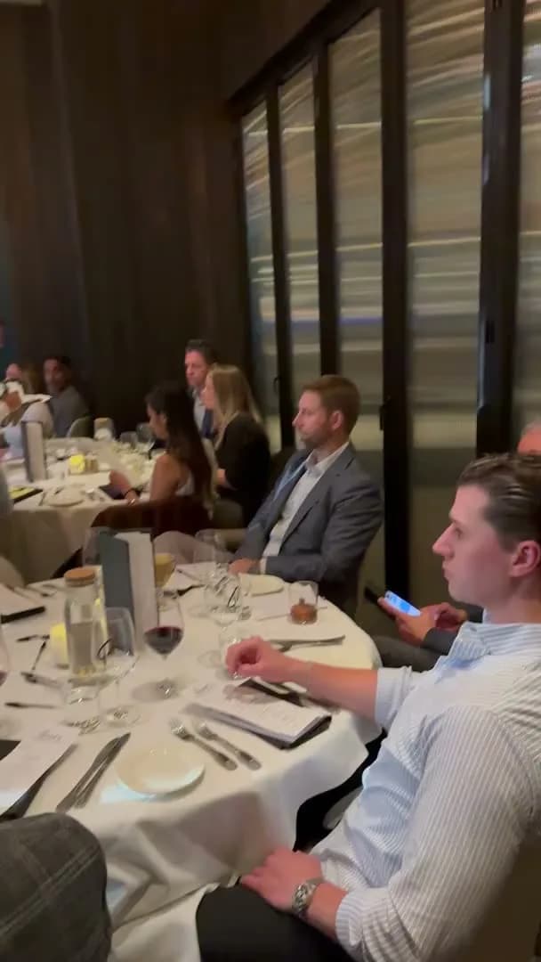 Guests at a table by the window, listening
