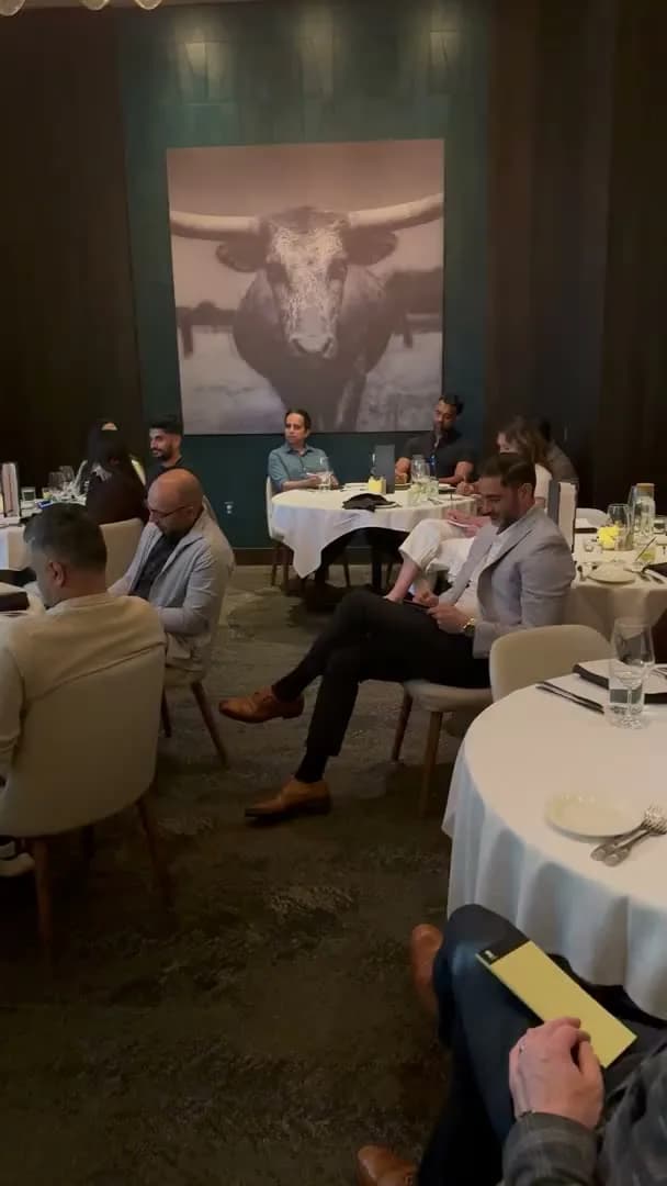 Guests seated across two tables under the longhorn photograph