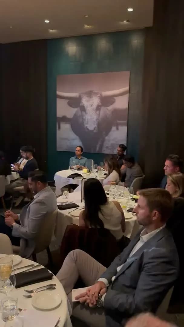 Guests watching the presentation from the far side of the room
