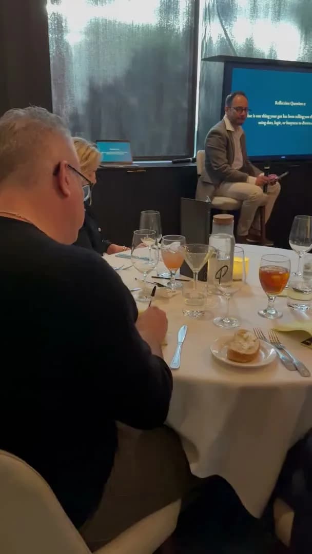 Guests writing while a reflection question sits on the screen behind them