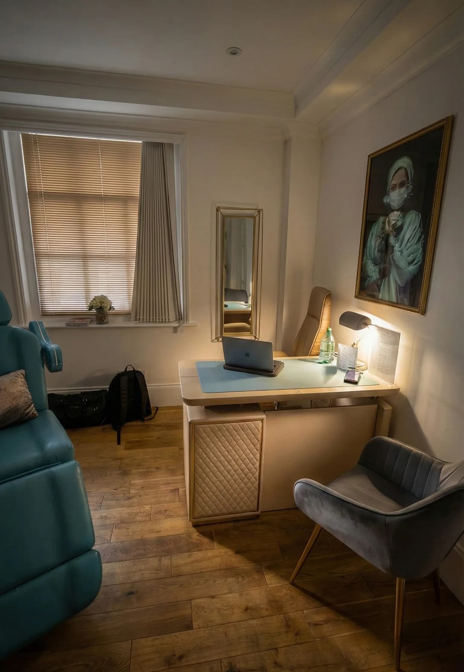 A treatment room at the LV8 London clinic, with a treatment chair, consultation desk and warm oak flooring